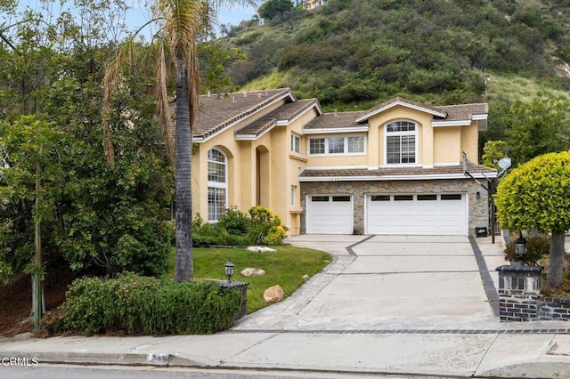 1985 Erin Way, Glendale, CA 91206 - traditional-style house with stucco siding, driveway, a garage, and stone siding