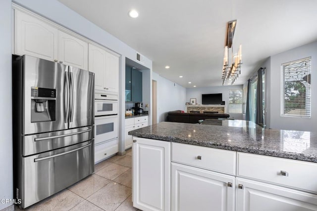 1985 Erin Way, Glendale, CA 91206 - kitchen with stainless steel refrigerator with ice dispenser, double oven, dark stone counters, white cabinetry, and recessed lighting