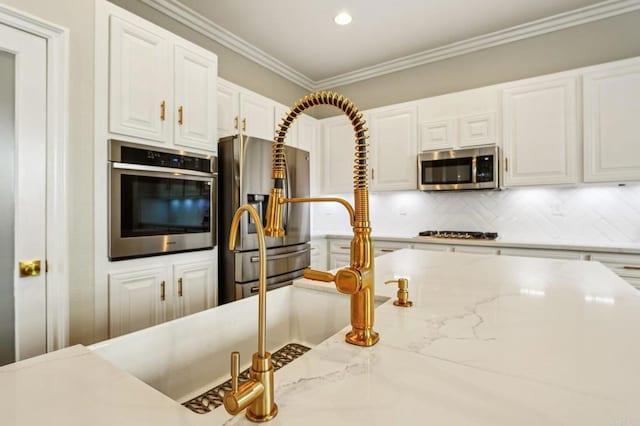 32555 Safflower St, Winchester, CA 92596 - kitchen with stainless steel appliances, white cabinets, crown molding, tasteful backsplash, and light stone countertops