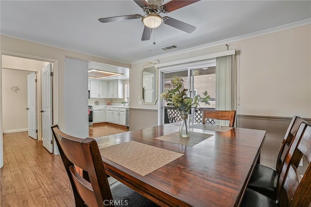 dining space featuring crown molding, light wood-style floors, ceiling fan, and baseboards