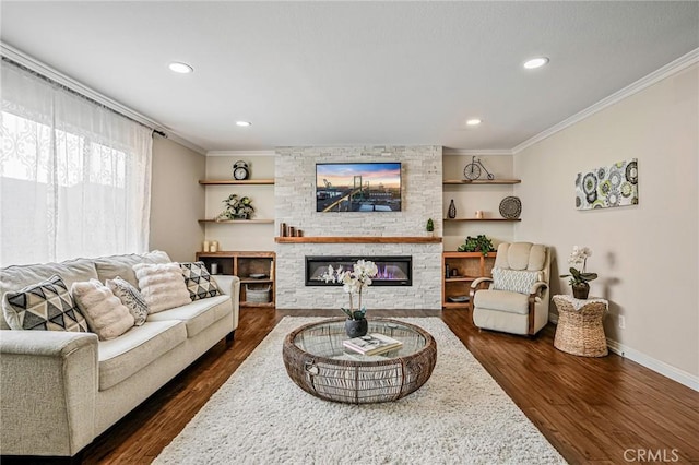 living area featuring ornamental molding, dark wood-type flooring, a stone fireplace, baseboards, and recessed lighting