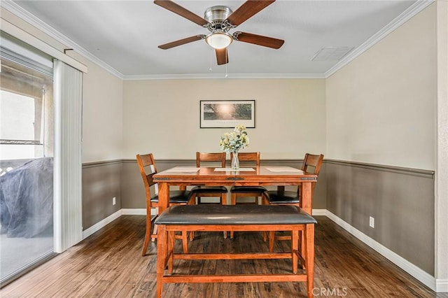 dining area with wood finished floors, ceiling fan, crown molding, and baseboards