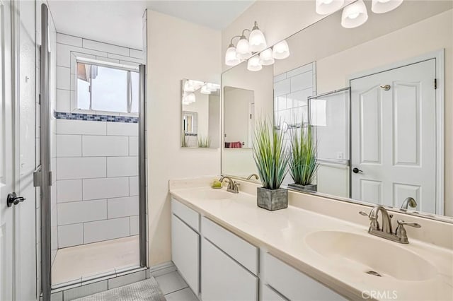 bathroom with a shower stall, double vanity, and tile patterned flooring