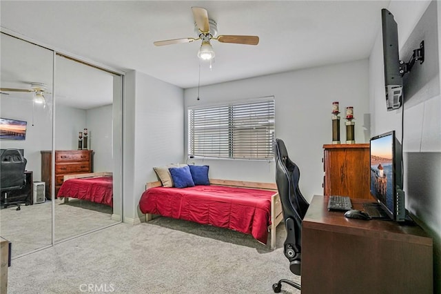 bedroom with an office area, carpet floors, a closet, and a ceiling fan
