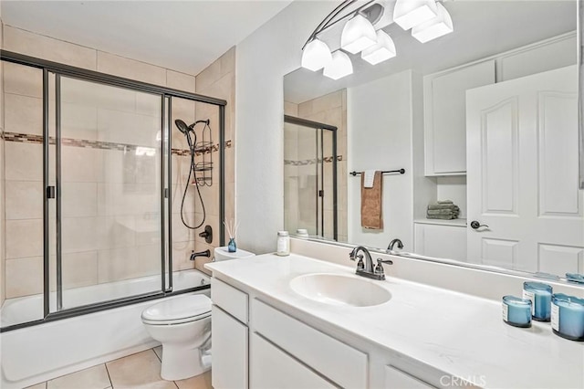 full bathroom with combined bath / shower with glass door, tile patterned flooring, toilet, and vanity