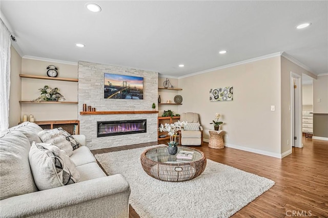 living room with a stone fireplace, crown molding, wood finished floors, baseboards, and recessed lighting