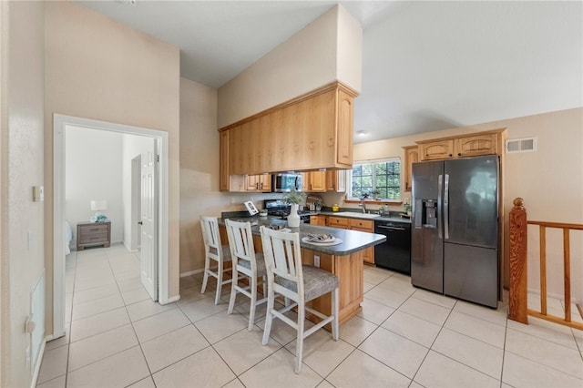 41225 Hacienda Dr, Murrieta, CA 92562 - kitchen featuring appliances with stainless steel finishes, a sink, light tile patterned flooring, a kitchen breakfast bar, and a peninsula