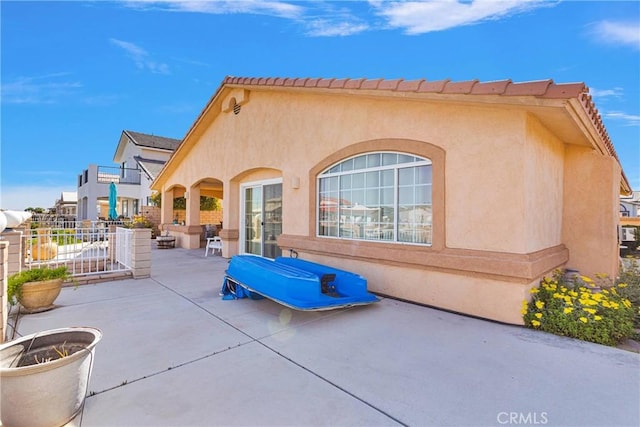 back of property with a patio and stucco siding