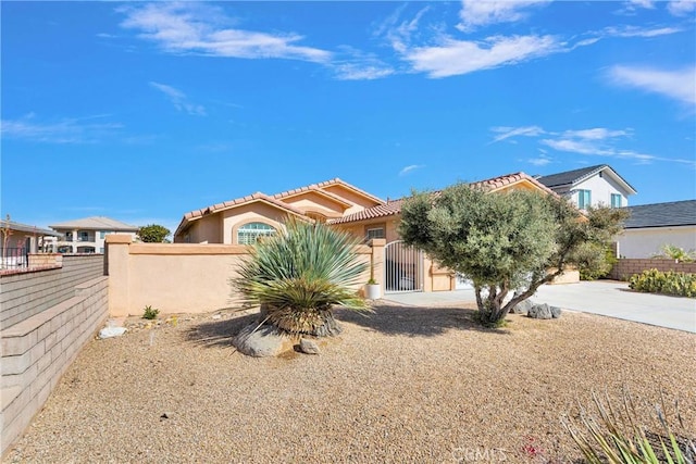 view of front of house featuring a fenced front yard, stucco siding, and a tiled roof