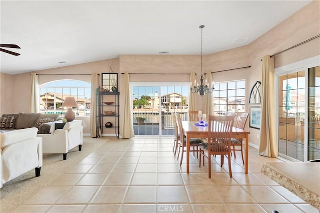 dining area with ceiling fan, vaulted ceiling, light tile patterned floors, a chandelier, and baseboards