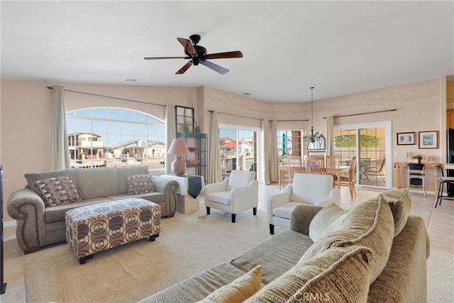 living room with ceiling fan and a chandelier