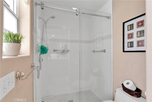 bathroom featuring toilet and a stall shower