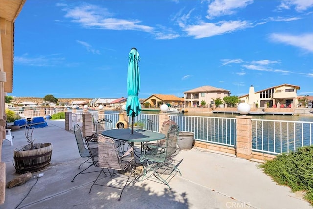 view of patio featuring a water view and outdoor dining area