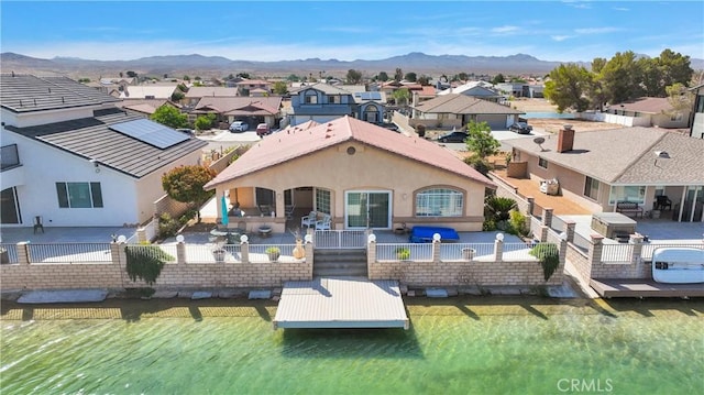 back of house featuring a fenced backyard, a patio area, a residential view, and a mountain view