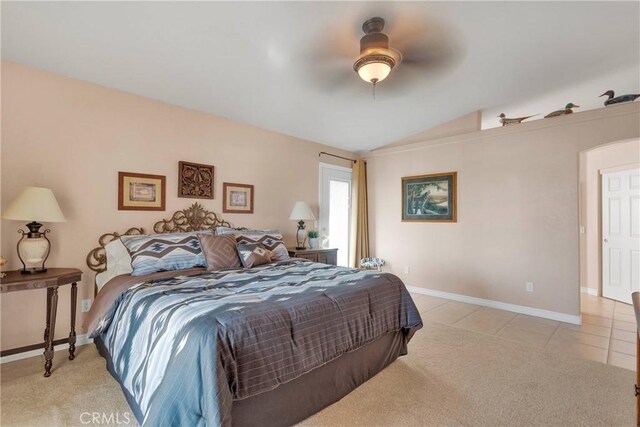 bedroom featuring vaulted ceiling, baseboards, light tile patterned flooring, light colored carpet, and a ceiling fan