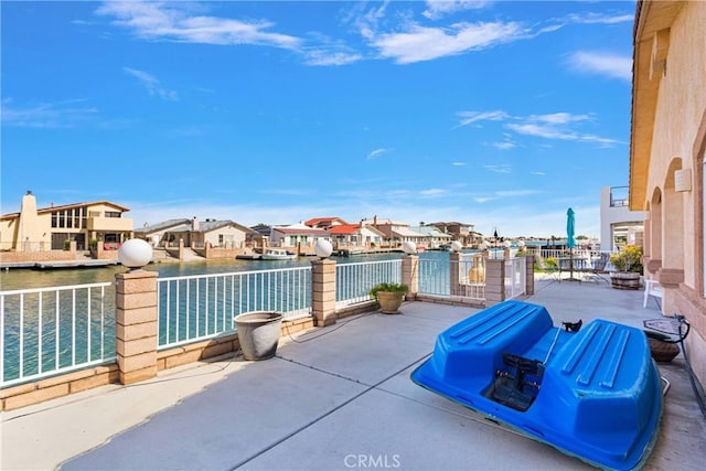view of patio / terrace featuring a residential view and a water view