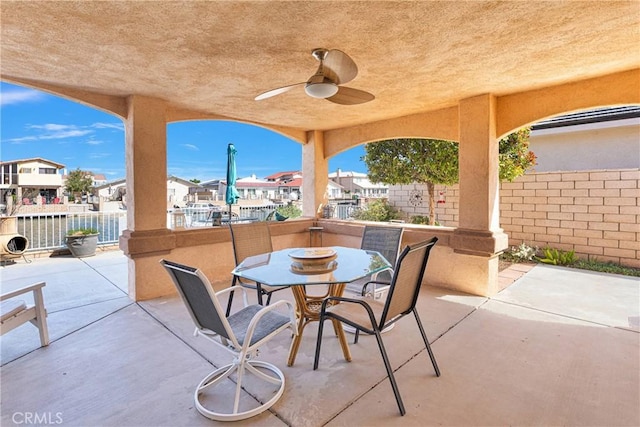 view of patio / terrace with a ceiling fan, fence, outdoor dining area, and a residential view