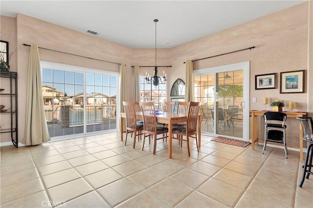 dining area with light tile patterned floors and a chandelier