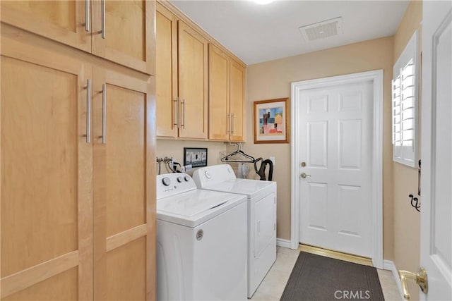 laundry room featuring separate washer and dryer, cabinet space, baseboards, and light tile patterned floors