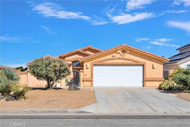view of front facade with stucco siding, a tile roof, driveway, a garage, and fence