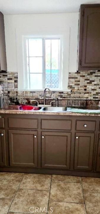 2305 Walter St, Huntington Park, CA 90255 - kitchen with backsplash, light tile patterned floors, and a sink