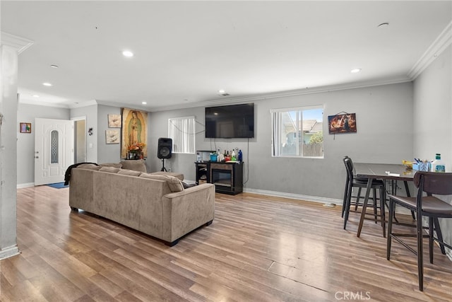 living area featuring ornamental molding, light wood-style floors, recessed lighting, and baseboards