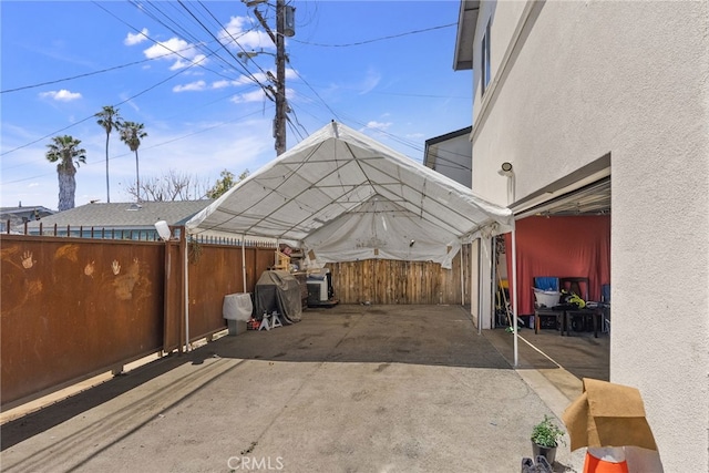 view of patio / terrace with fence and a carport