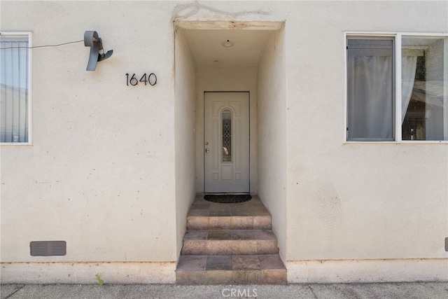 property entrance with stucco siding