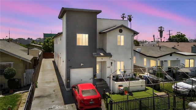 view of front of home featuring stucco siding, fence, an attached garage, and driveway