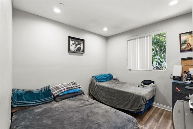 bedroom featuring wood finished floors, recessed lighting, and baseboards
