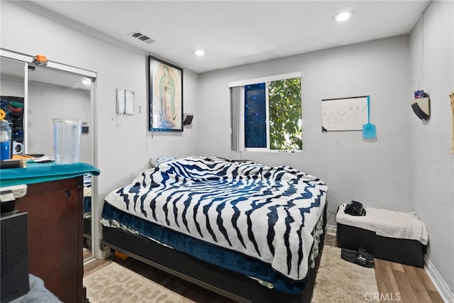 bedroom featuring wood finished floors, recessed lighting, and baseboards