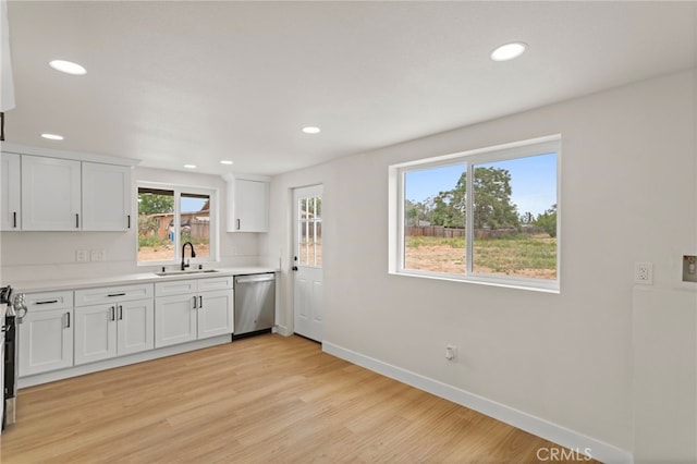 kitchen with dishwasher, a sink, recessed lighting, baseboards, and light wood-style flooring
