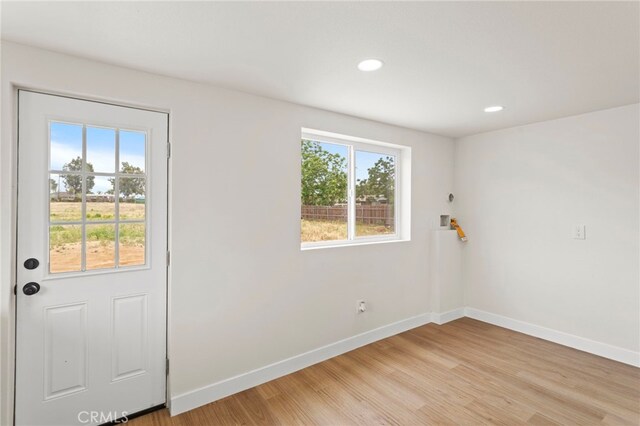 doorway to outside featuring baseboards, light wood-style floors, and recessed lighting