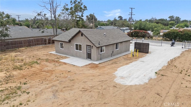 back of property featuring stucco siding and fence
