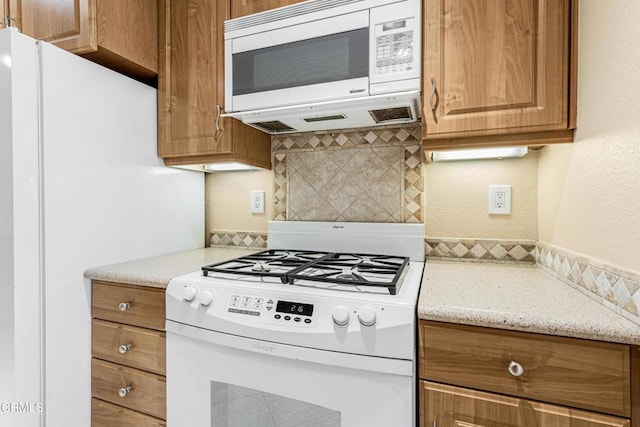 2451 Manet Ln, Simi Valley, CA 93063 - kitchen featuring white appliances, decorative backsplash, brown cabinets, light stone counters, and a textured wall