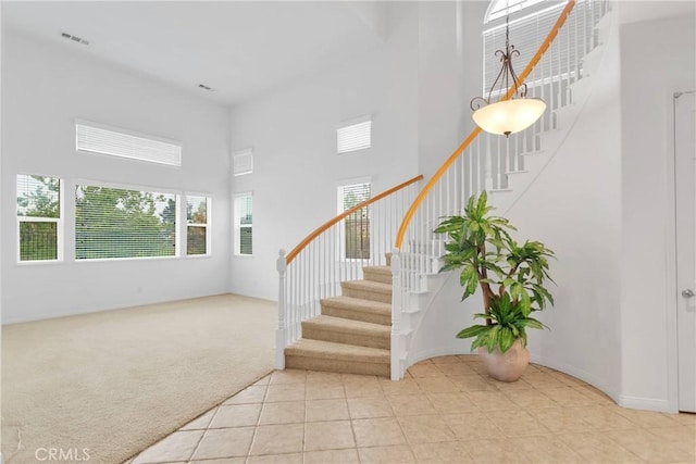 34113 Castle Pines Dr, Yucaipa, CA 92399 - stairway with a towering ceiling, tile patterned floors, and carpet flooring