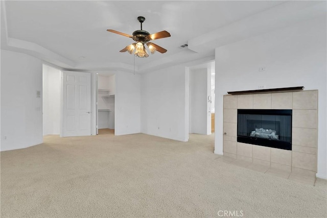 34113 Castle Pines Dr, Yucaipa, CA 92399 - unfurnished living room with a tray ceiling, carpet flooring, a ceiling fan, and a tile fireplace