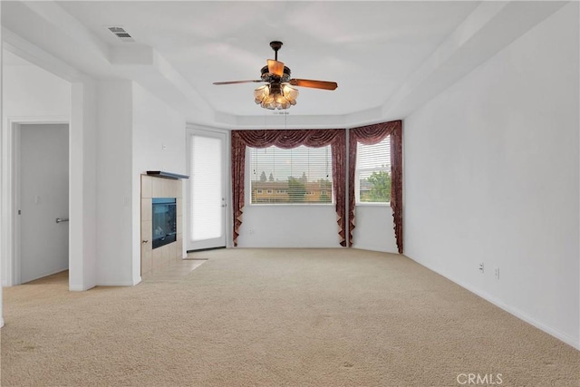 34113 Castle Pines Dr, Yucaipa, CA 92399 - empty room featuring carpet floors, a ceiling fan, and a tiled fireplace