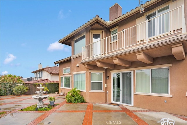 34113 Castle Pines Dr, Yucaipa, CA 92399 - rear view of property with a patio, a balcony, fence, and stucco siding