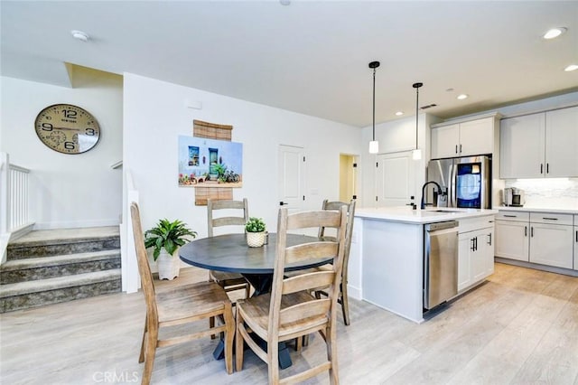 1053 Tiburon Way, San Luis Obispo, CA 93401 - kitchen with stainless steel appliances, light wood-type flooring, light countertops, a sink, and decorative backsplash