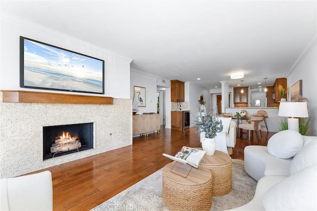 201 Bay Shore Ave Unit 209, Long Beach, CA 90803 - living area featuring wood finished floors, crown molding, wine cooler, and a tiled fireplace