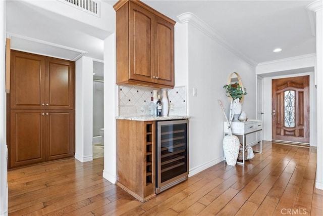 201 Bay Shore Ave Unit 209, Long Beach, CA 90803 - indoor dry bar featuring wine cooler, light wood-type flooring, crown molding, decorative backsplash, and baseboards