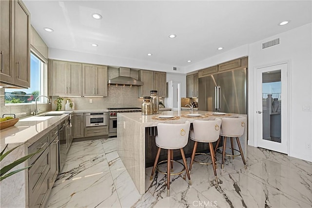 28 Brownsbury Rd, Laguna Niguel, CA 92677 - kitchen featuring premium appliances, wall chimney range hood, a sink, a center island with sink, and backsplash