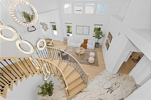 28 Brownsbury Rd, Laguna Niguel, CA 92677 - stairs with marble tiled flooring, a high ceiling, and baseboards