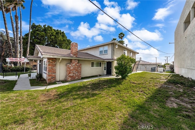 2004 Palm Ave, Highland, CA 92346 - back of property featuring a chimney, stucco siding, and a lawn