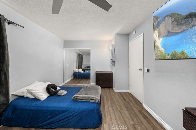 2004 Palm Ave, Highland, CA 92346 - bedroom featuring wood finished floors, a closet, a textured ceiling, a ceiling fan, and baseboards