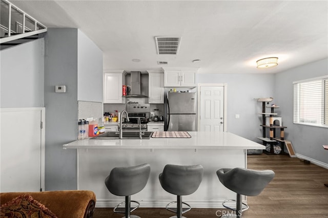 2004 Palm Ave, Highland, CA 92346 - kitchen with stainless steel appliances, wall chimney range hood, a sink, a peninsula, and a kitchen bar