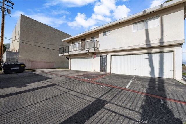 2004 Palm Ave, Highland, CA 92346 - view of front of property featuring a balcony, stucco siding, and an attached garage