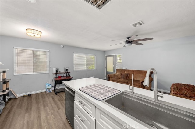 2004 Palm Ave, Highland, CA 92346 - kitchen featuring a sink, wood finished floors, light countertops, dishwashing machine, and white cabinetry