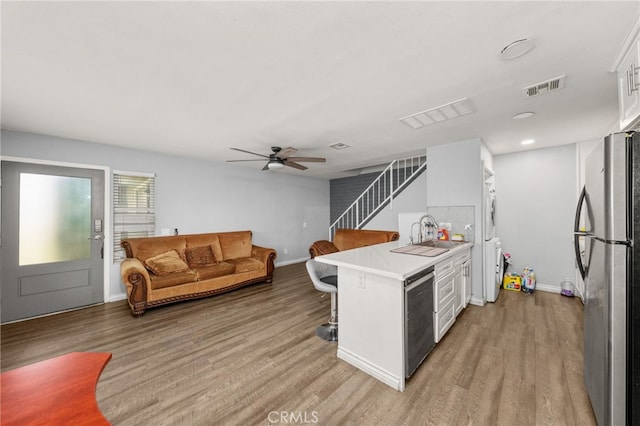 2004 Palm Ave, Highland, CA 92346 - kitchen featuring freestanding refrigerator, a sink, a breakfast bar, light wood finished floors, and baseboards